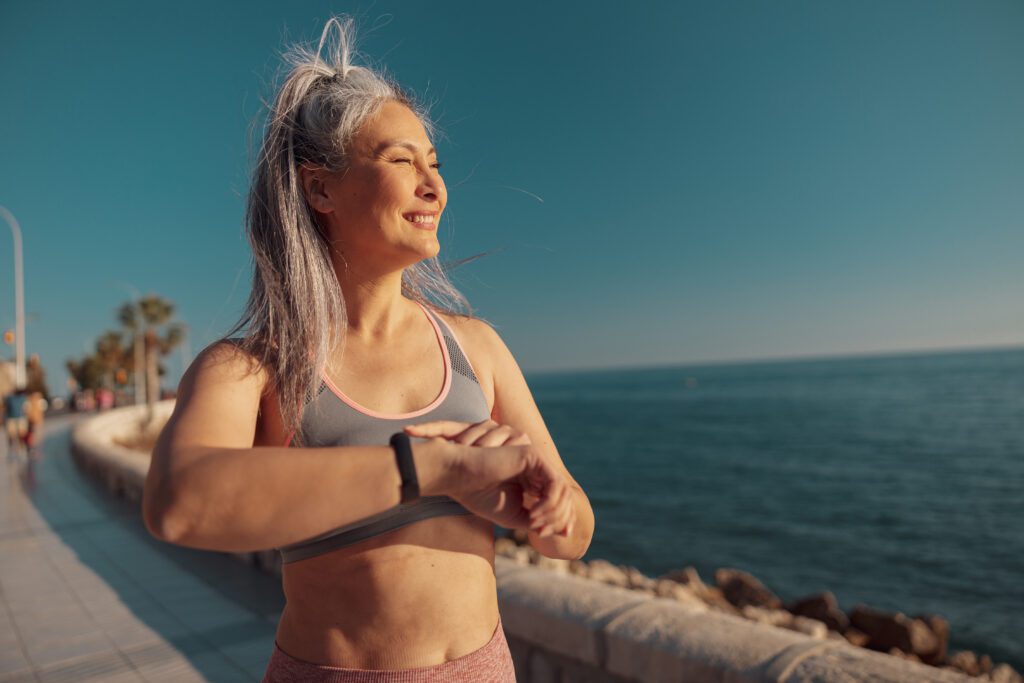 mulher tomando sol com roupa de academia.