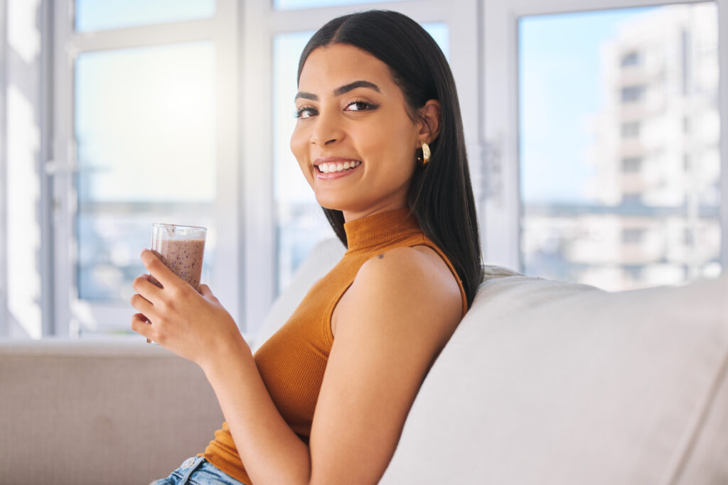 Mulher tomando suco com colágeno.