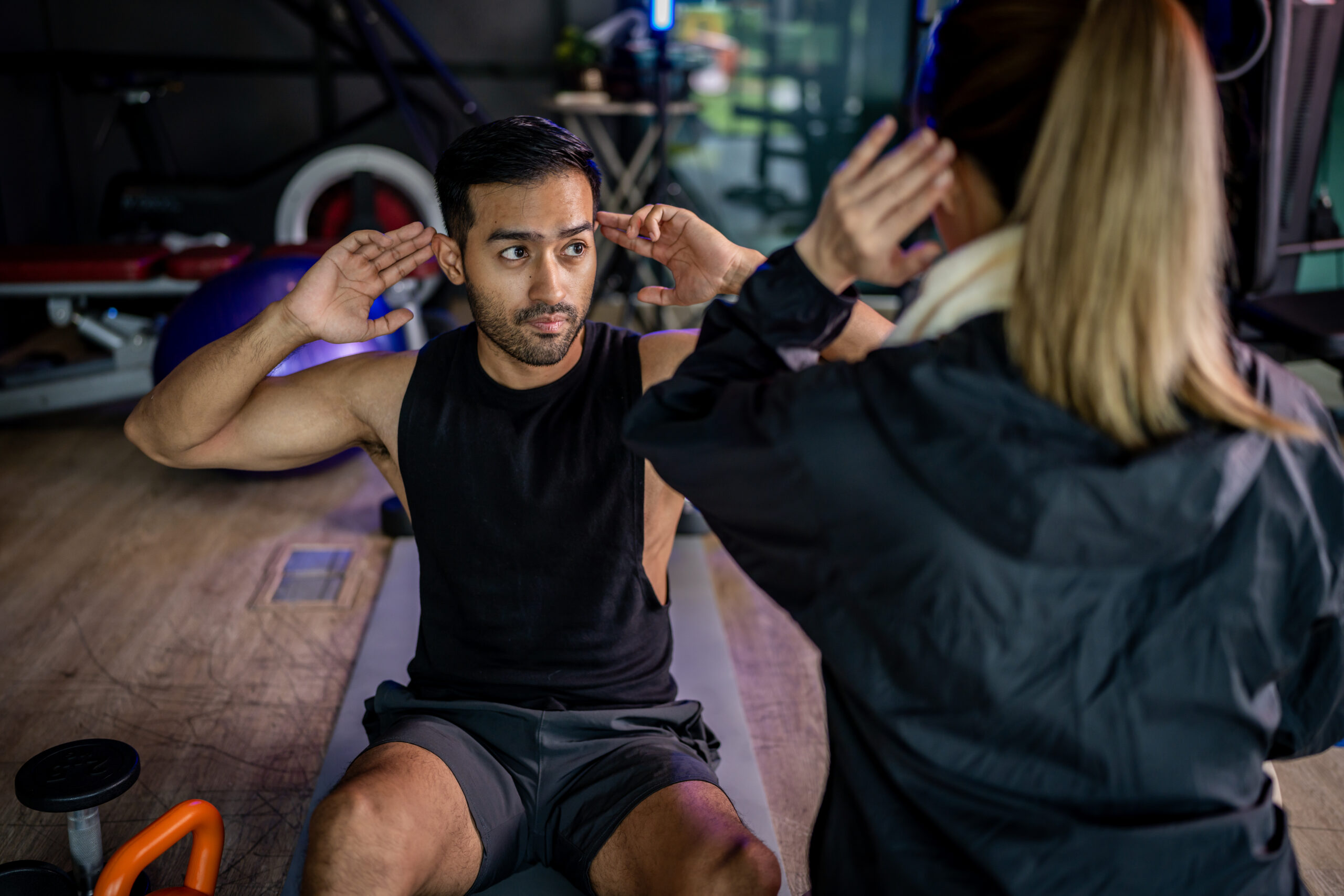 Asian man and woman working out, one is a trainer, the other is an exerciser.